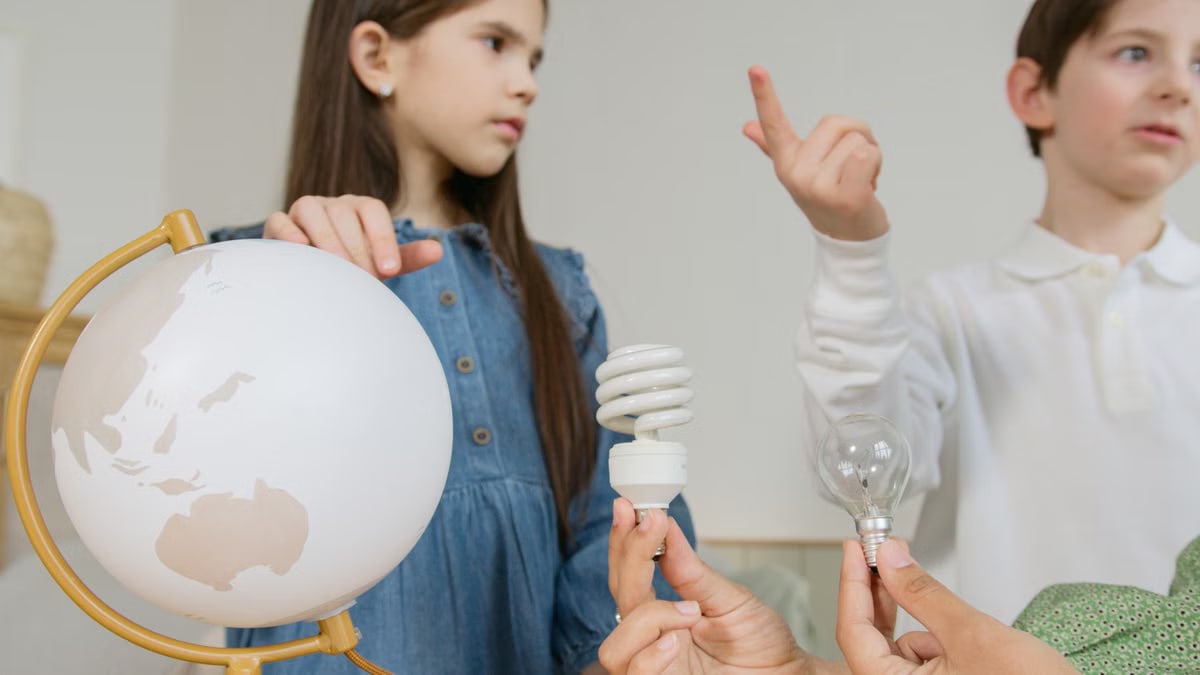 Children exploring renewable energy concepts with a globe, lightbulbs, and teamwork.